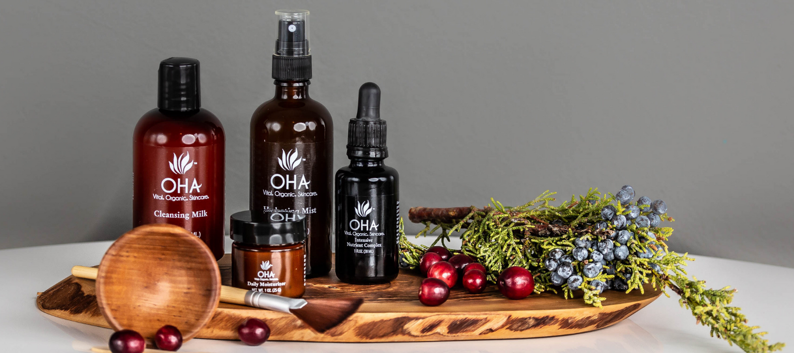 all-natural skincare products sitting on wooden board with festive sprigs