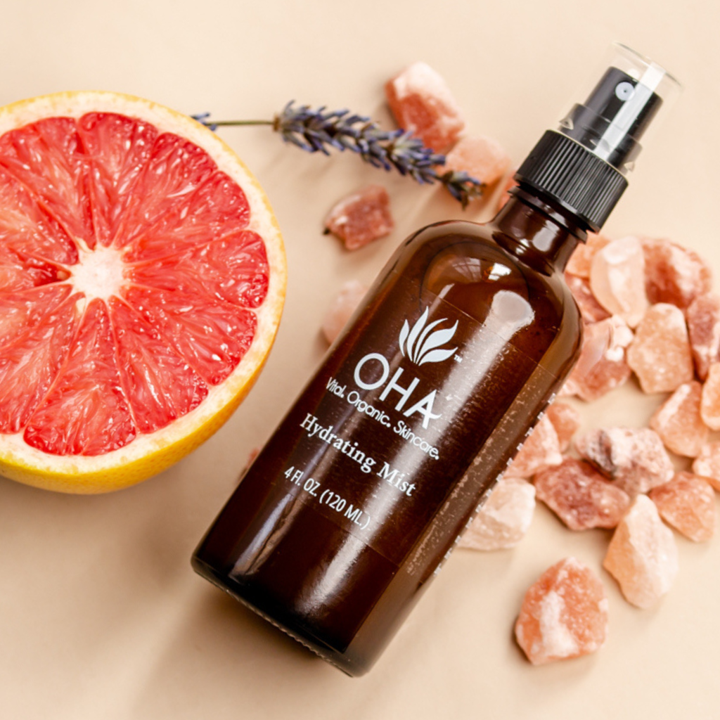 hydrating facial mist with rose and lavender in glass spray bottle surrounded by grapefruit and lavender sprig