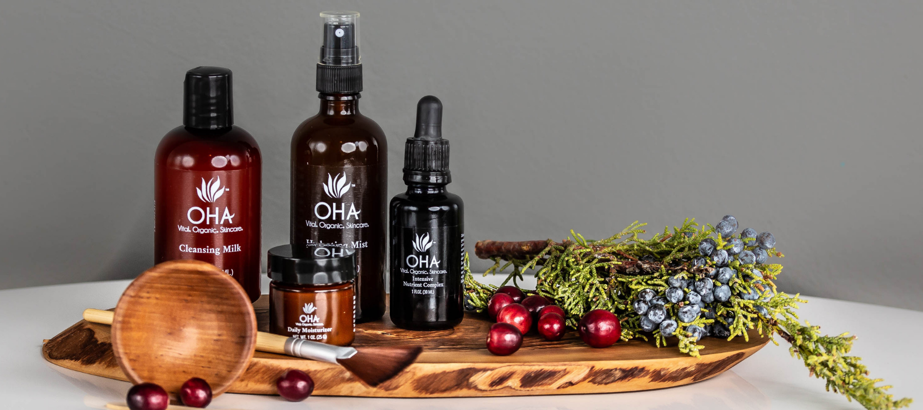 all-natural skincare products sitting on wooden board with festive sprigs