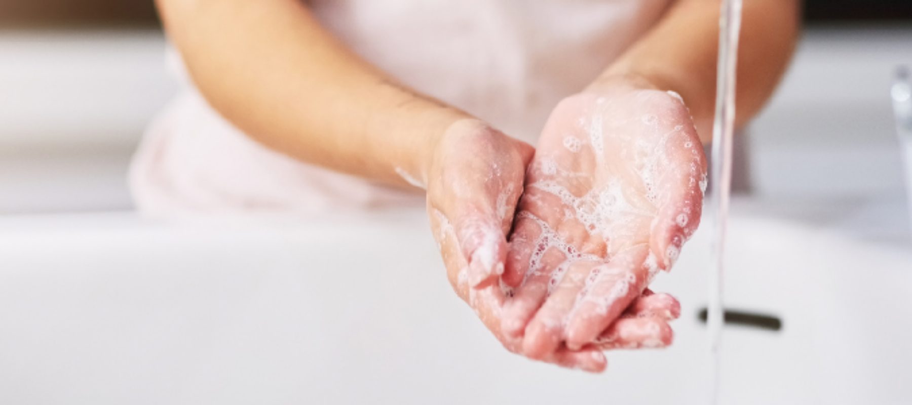 woman washing hands with soap and water