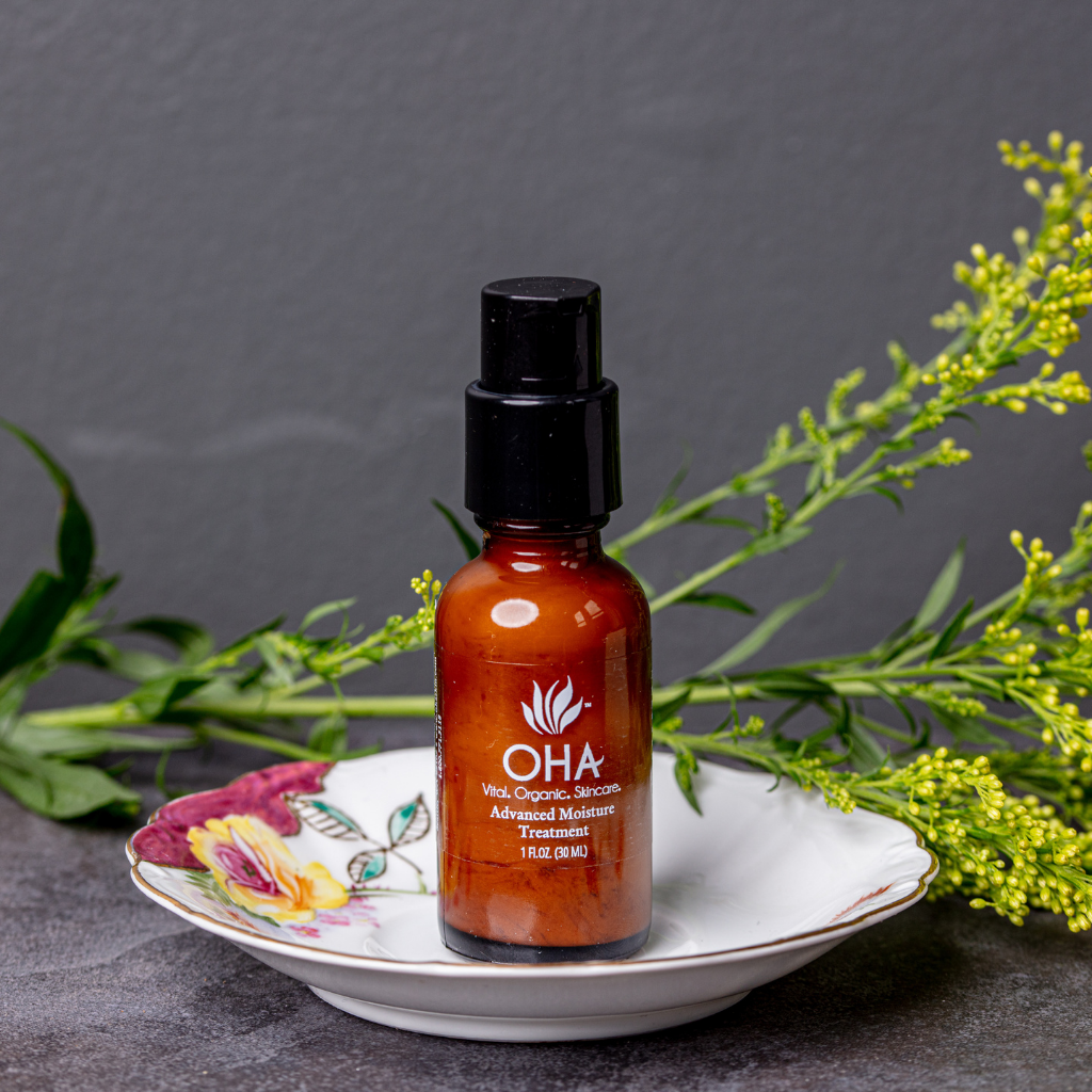 Bottle of firming and healing face cream sitting on plate with fresh sprig 