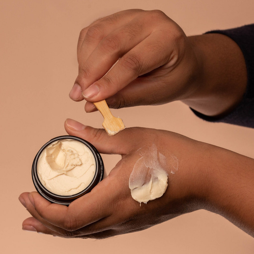 Woman applying luxurious organic cream with hand ground sugar and shea butter to her hand
