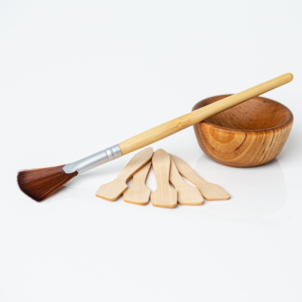 bamboo vegan fan brush shown with wooden bowl and bamboo applicators